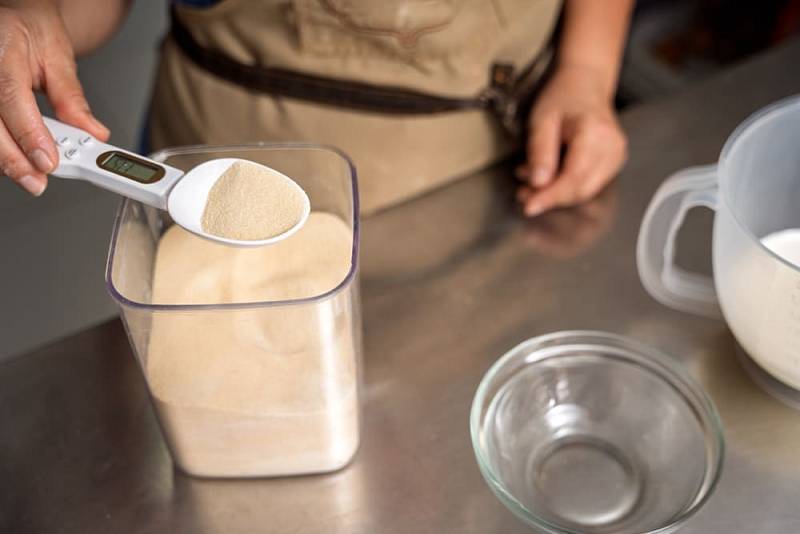 Professional,Baker,Using,A,Digital,Spoon,Scale,To,Accurately,Measure