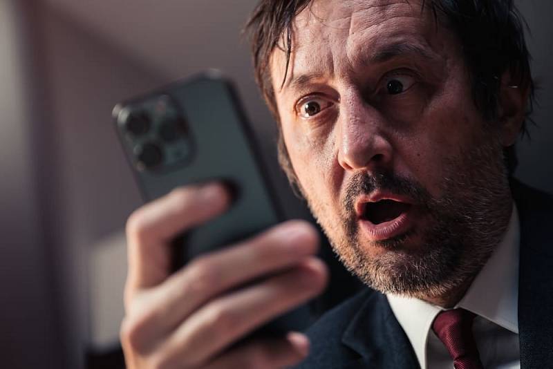 Shocked,Businessman,Reading,Text,Message,On,Smartphone,With,Surprised,Facial